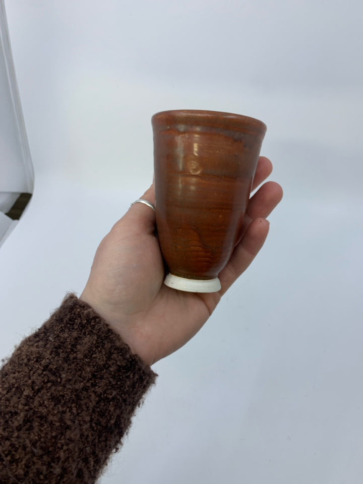FOOTED RUST COLORED POTTERY VASE.