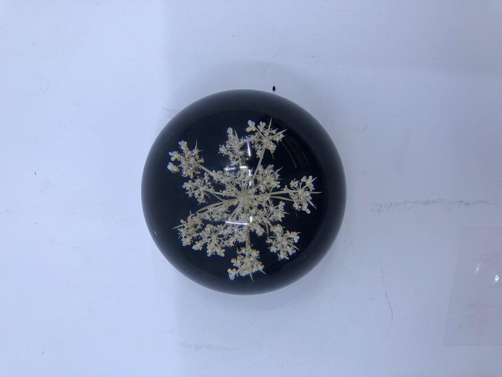 RESIN PAPER WEIGHT BLACK BOTTOM W/ WHITE FLOWERS.