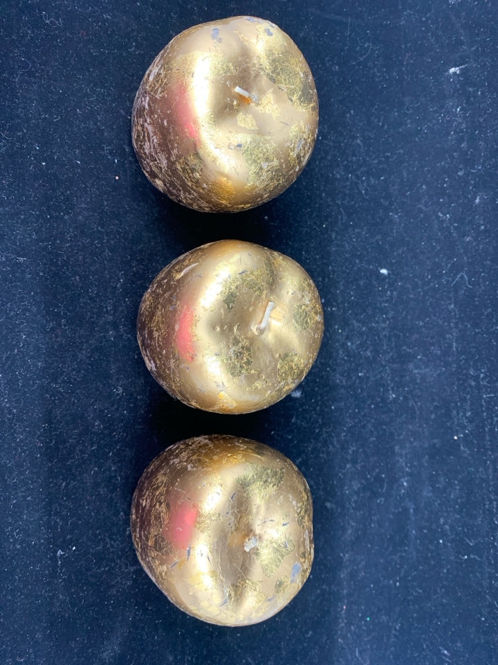 3 GOLD APPLE SHAPED CANDLES.