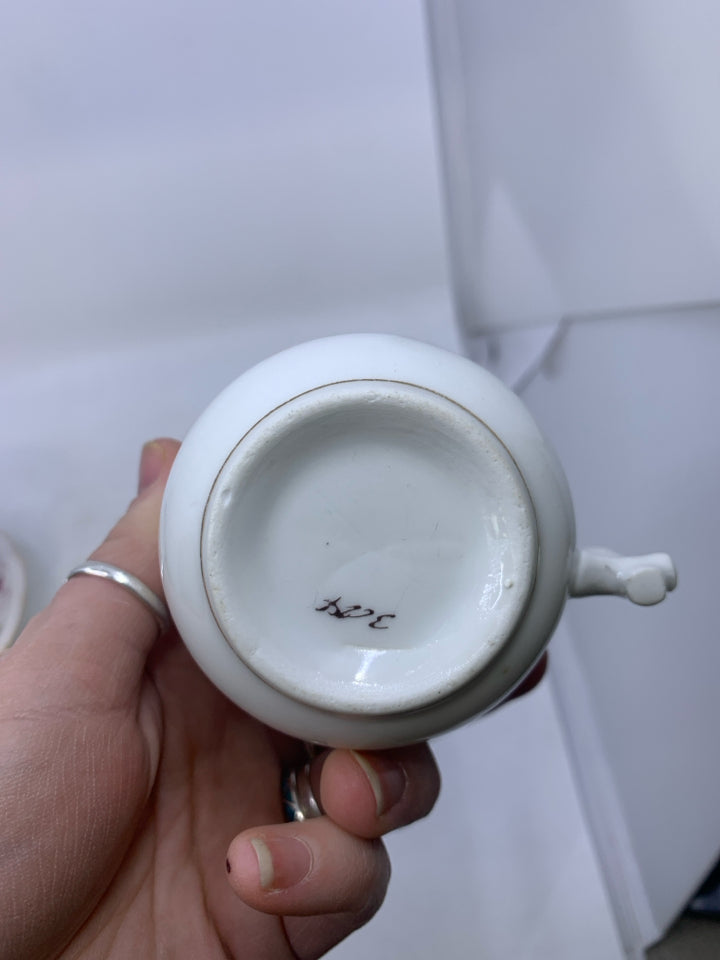 WHITE TEA CUP W/ 2 CHERUBS SITTING ON ROCK TEA CUP SAUCER.