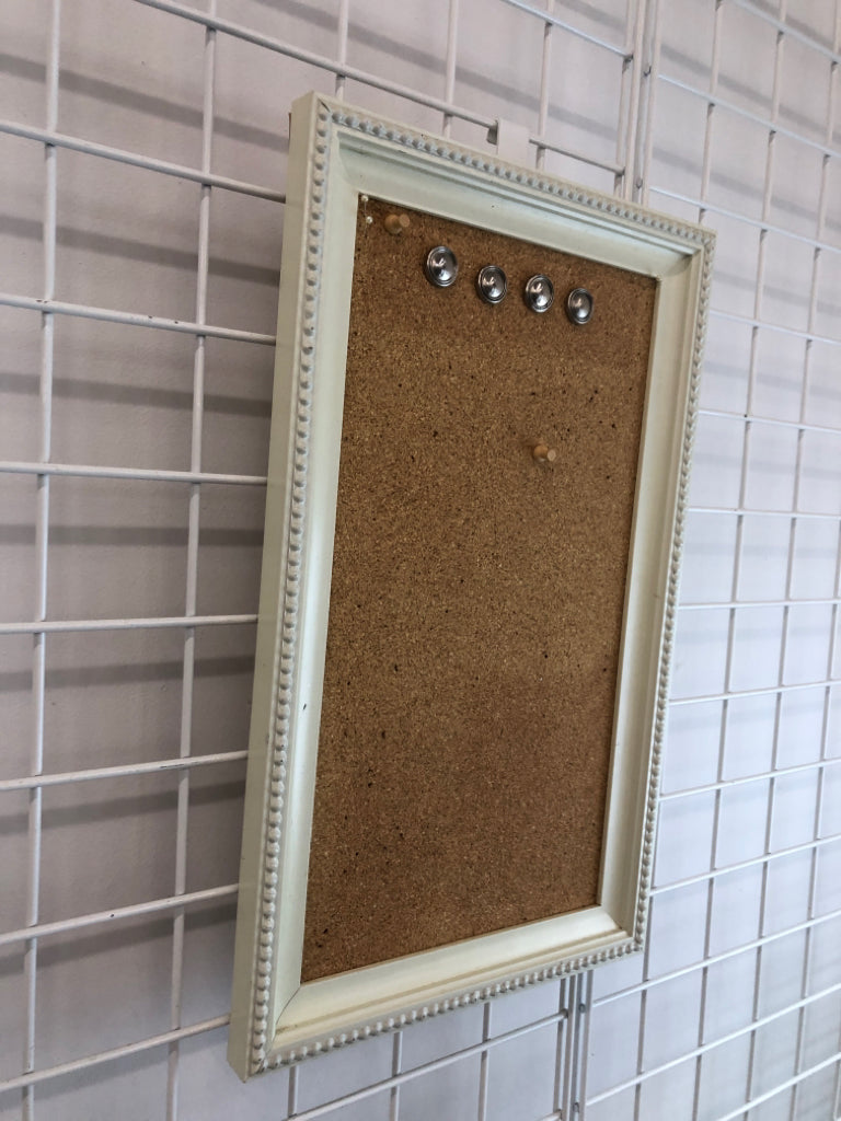 PIN BOARD W/PINS IN WHITE FRAME.