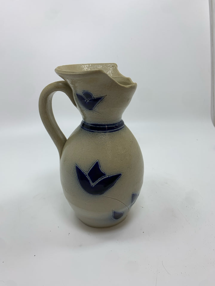 TAN STONEWARE SALT GLAZE PITCHER W/BLUE GLAZED FLORAL DESIGN.