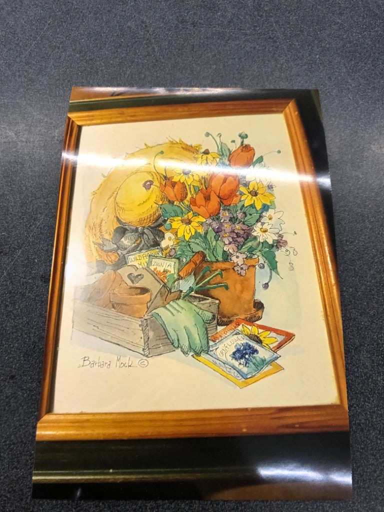 BARBARA MOCK PAINTING OF GARDENING SUPPLIES WALL ART IN DARK GREEN FRAME.