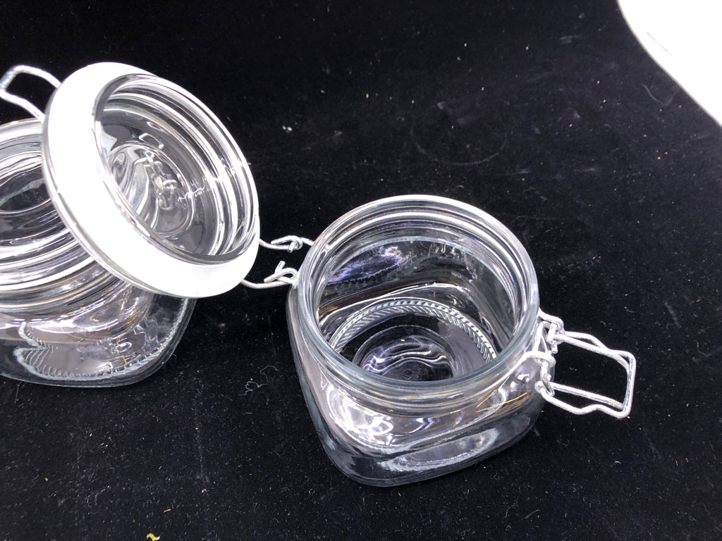 2 SHORT CLEAR GLASS CANISTERS W/ METAL CLASP LID.
