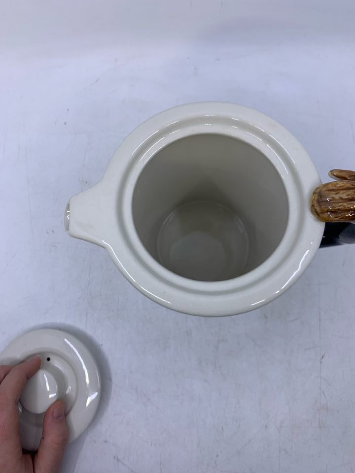 CREAM W/ MONKEY ON IT AND ARM AS HANDLE.