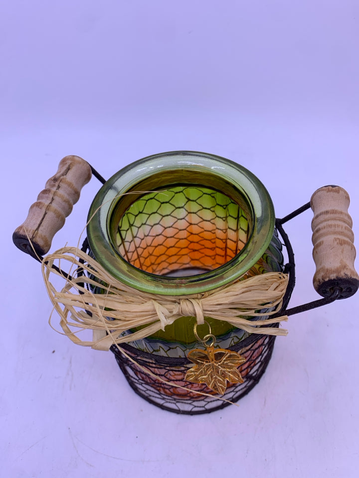 GLASS GREEN/ORANGE RIBBED JAR IN METAL CHICKEN WIRE INSERT CANDLE HOLDER.