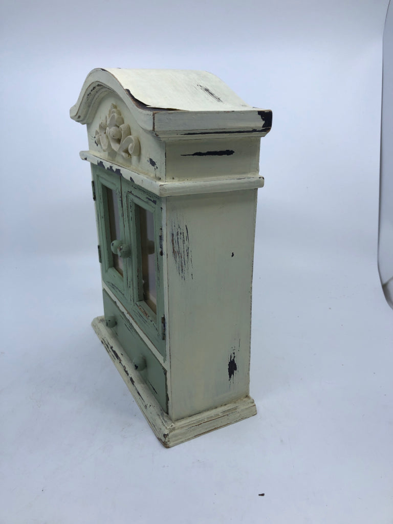 SMALL DISTRESSED PAINTED CABINET MINT GREEN+WHITE W/ SCROLL DESIGN.