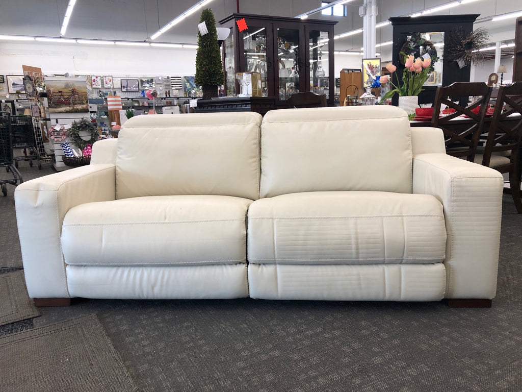 WHITE FAUX LEATHER RECLINING LOVE SEAT.