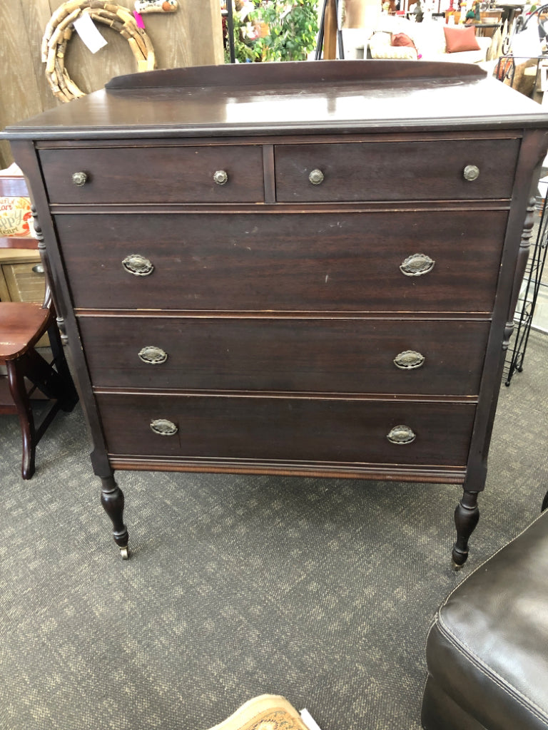VTG DARK WOOD DRESSER W/5 DRAWERS & ORNATE METAL PULLS ON WHEELS.
