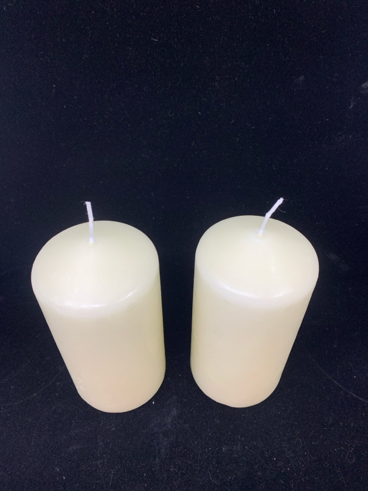 2 CREAM PILLAR CANDLES.