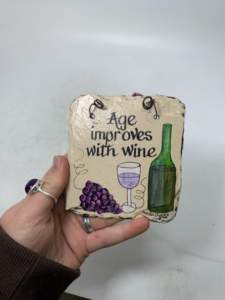 SMALL PAINTED AGE IMPROVES W/ WINE STONE SLATE WALL HANGING.