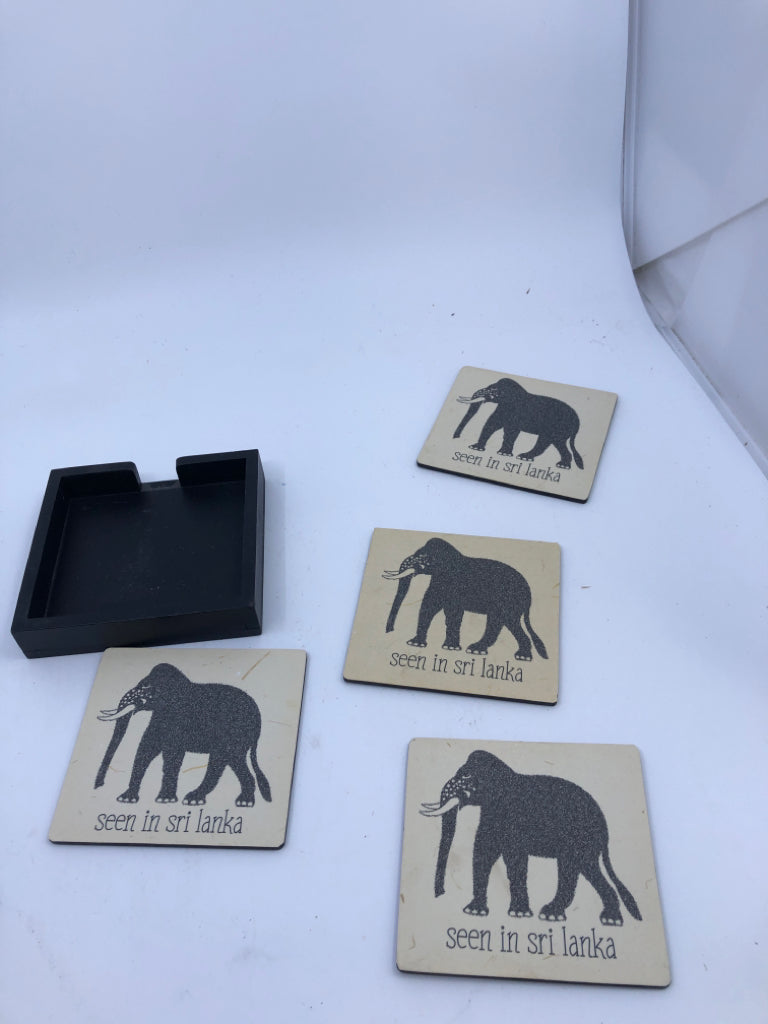 4 ELEPHANT COASTERS IN BLACK HOLDER.