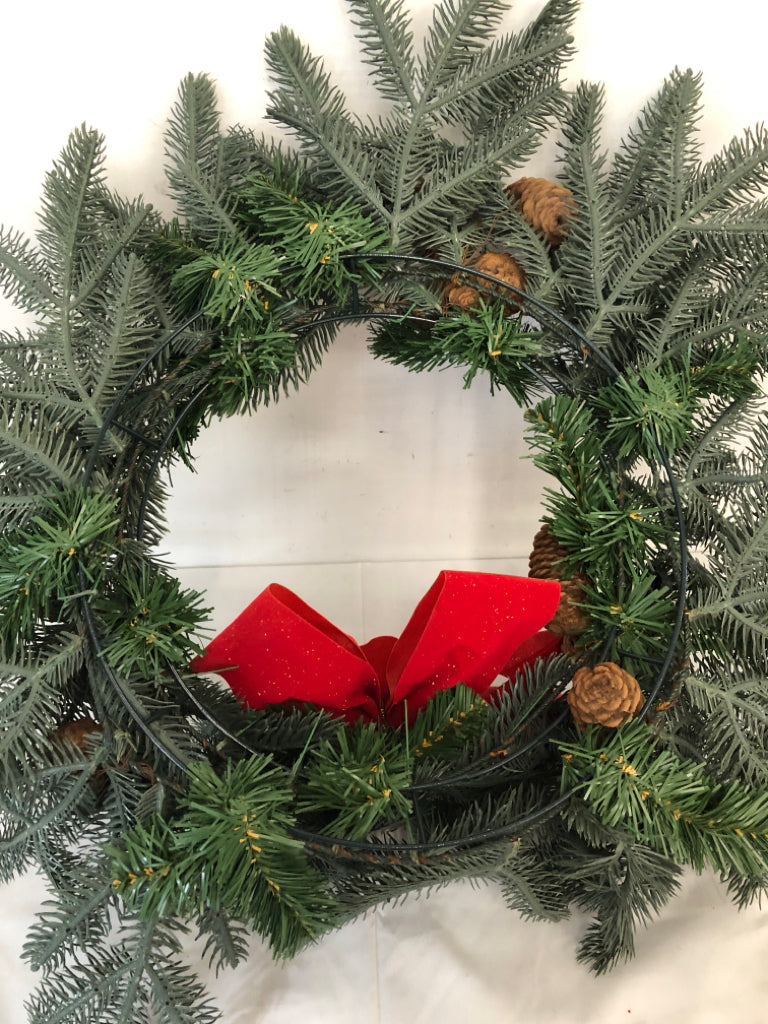 LARGE WREATH W PINE CONES AND RED BOW.