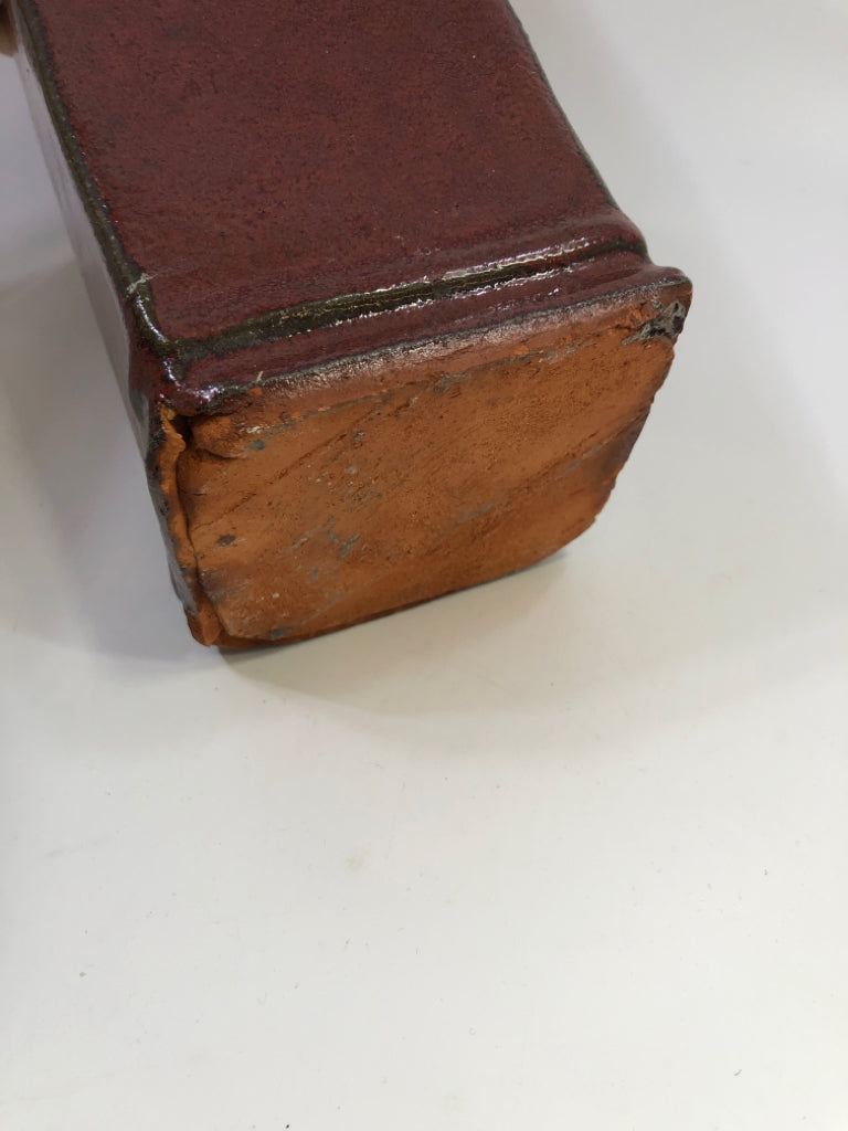 RED CERAMIC SQUARE VASE W/FAUX PURPLE FLOWERS.