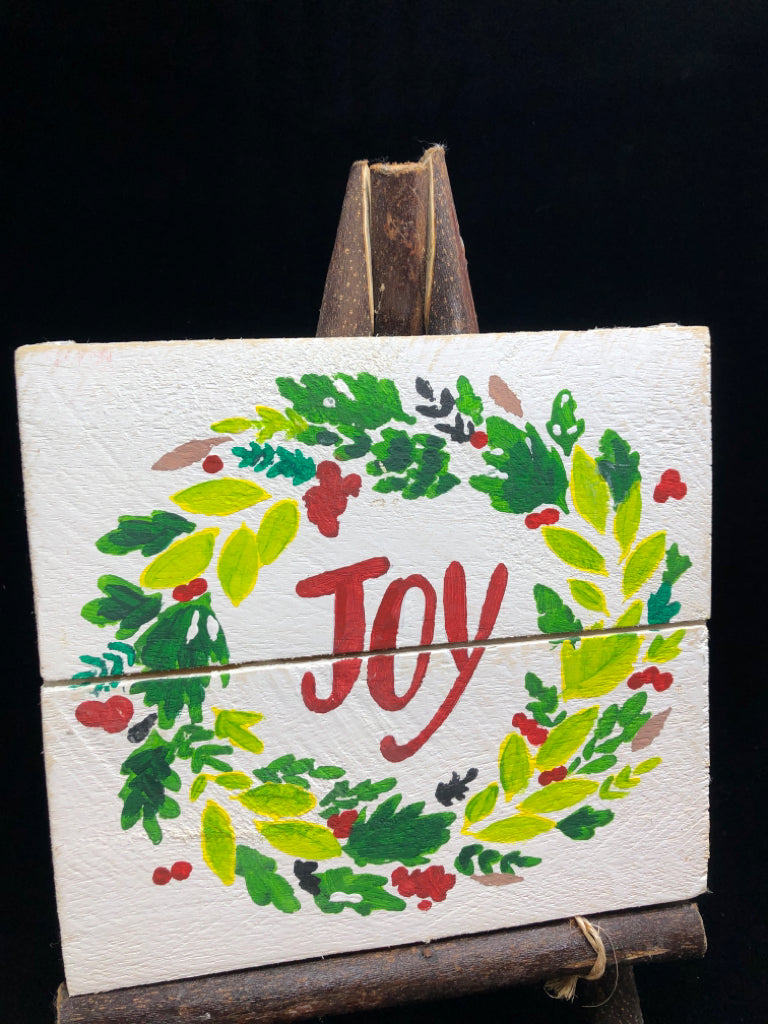 'JOY' WOOD SIGN ON BRANCHES.