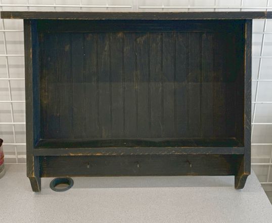DISTRESSED BLACK WALL SHELF W/ PEG HOOKS.
