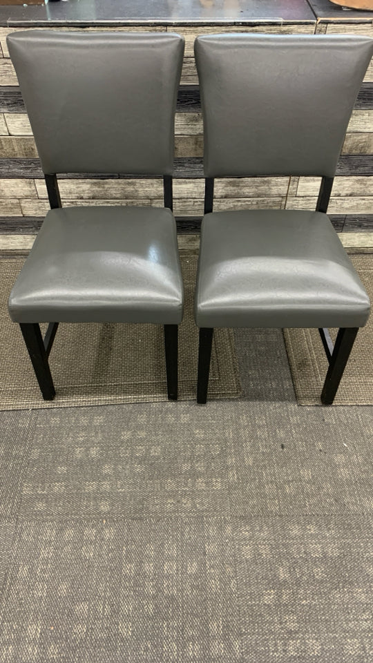 2 GRAY FAUX LEATHER CHAIRS W/BLACK WOOD LEGS.