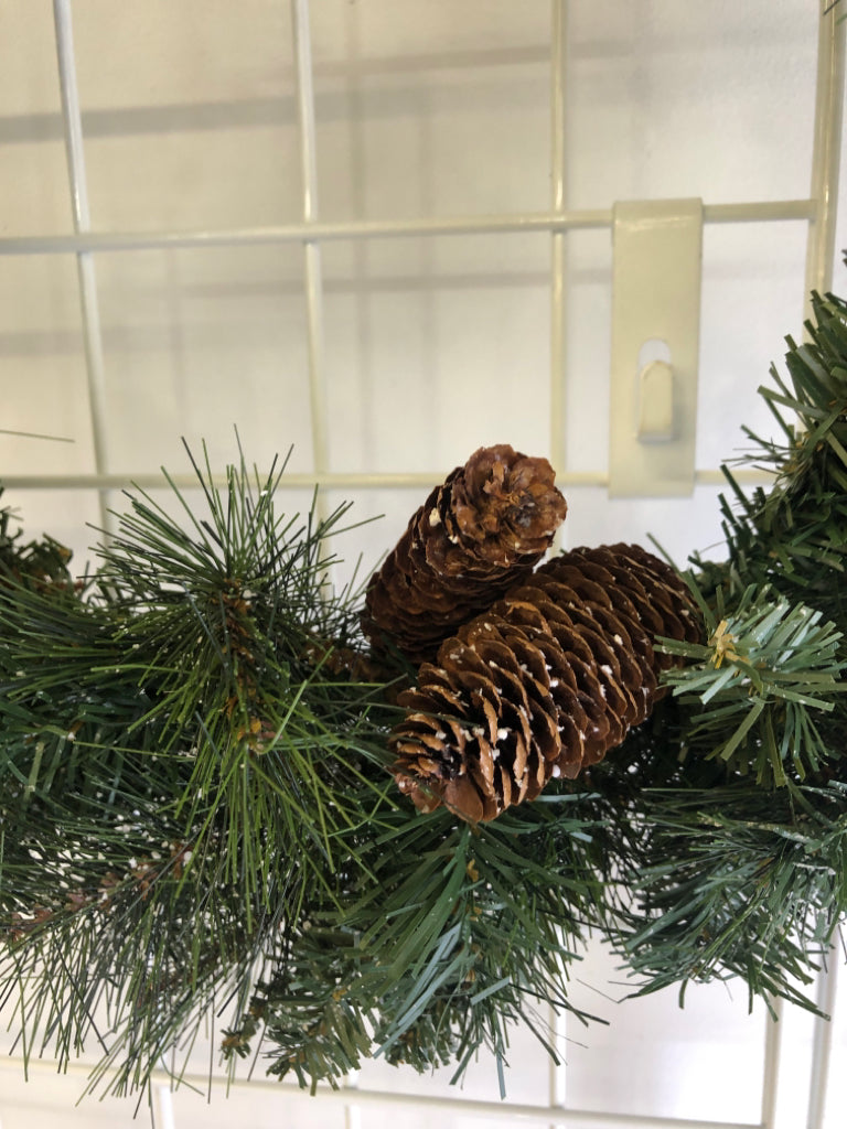 PINE WREATH W/PINECONES AND FAUX SNOW.