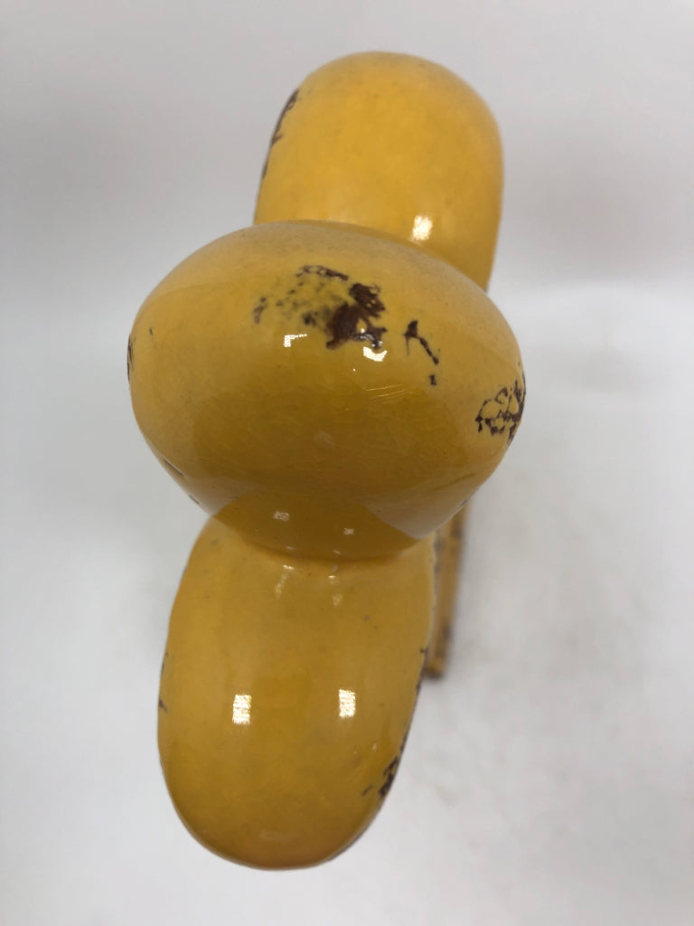 YELLOW FLEUR-DE-LIS FIGURINE.