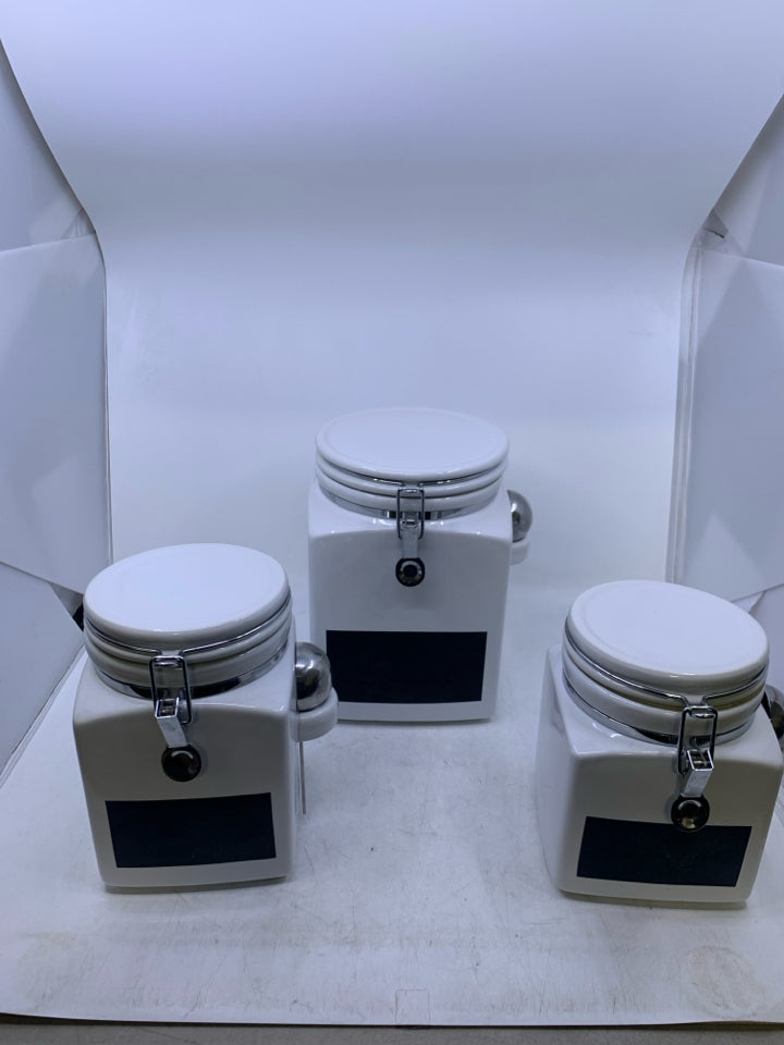 3 PC WHITE CANISTER SET W/ CHALK BOARD LABEL AND METAL SPOONS.