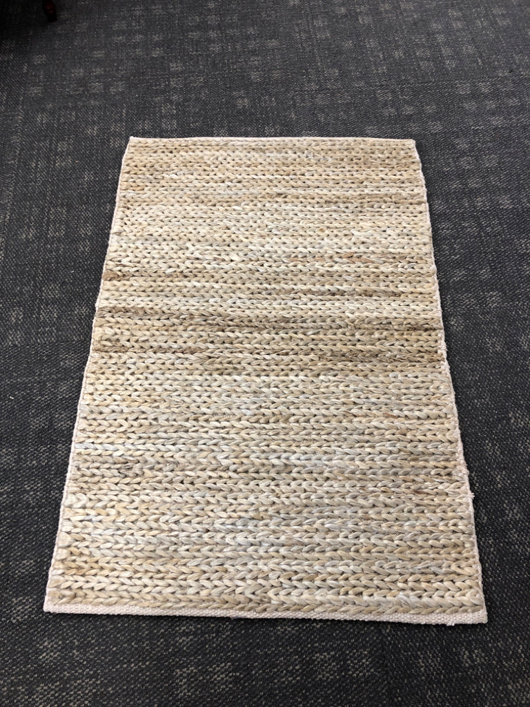 BRAIDED GREY RUG.