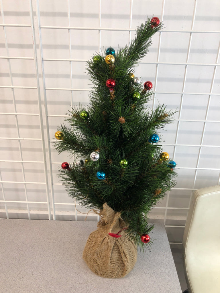 FAUX TREE W/COLORFUL ORNAMENTS IN BURLAP BASE.