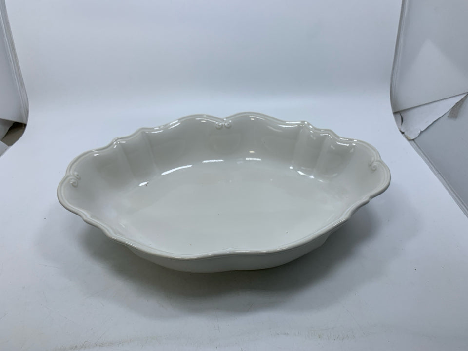 OFF WHITE OVAL STONEWARE SERVING BOWL W/ DETAILED EDGE.