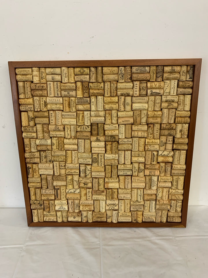 WINE CORKS IN A WOOD FRAME.