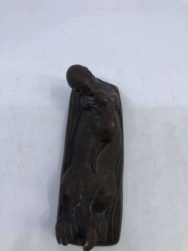 BROWN OTTER HOLDING BABY SWIMMING.