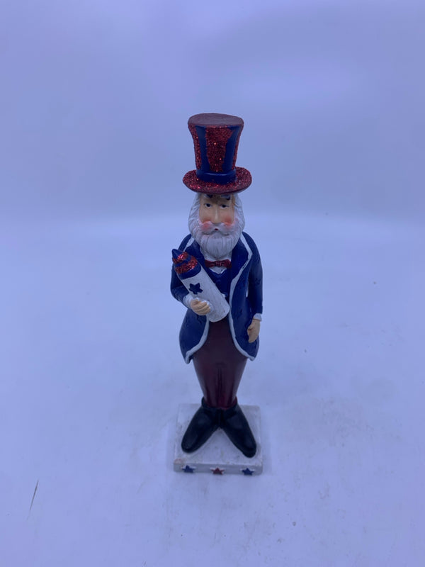 RESIN UNCLE SAM HOLDING ROCKET ON WHITE STAND.