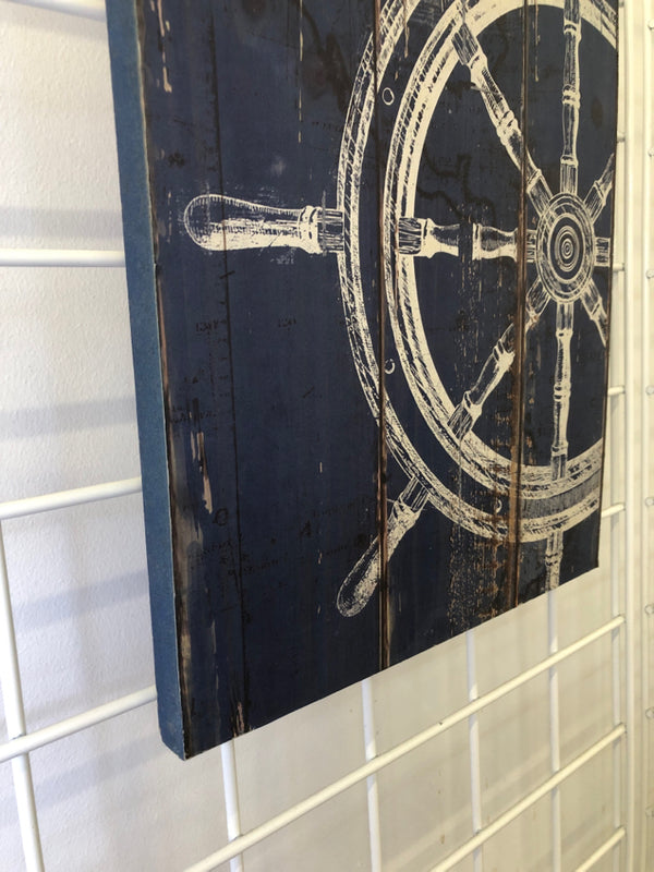 DISTRESSED WHITE SHIP WHEEL ON BLUE BACKGROUND WALL HANGING.