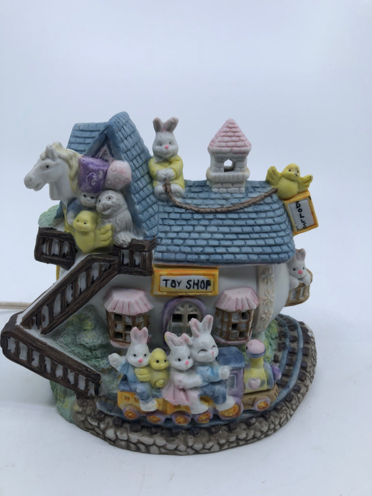 CERAMIC VILLAGE TOY SHOP LIGHT-UP EASTER DECORATION.