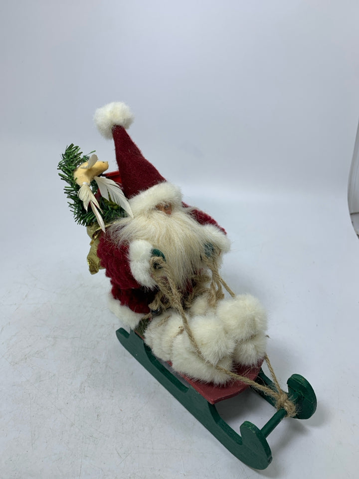 SMALL PLUSH SANTA ON GREEN SLED.