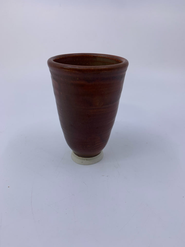 FOOTED RUST COLORED POTTERY VASE.