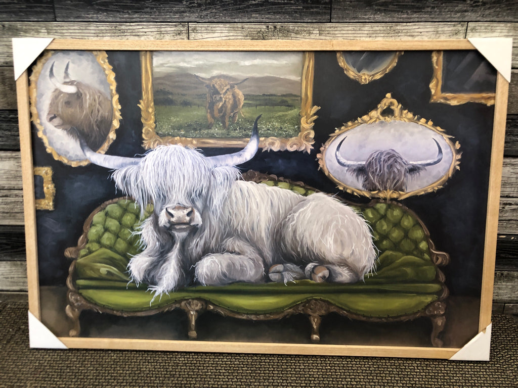 HIGHLAND COW SITTING ON GREEN COUCH WALL ART.