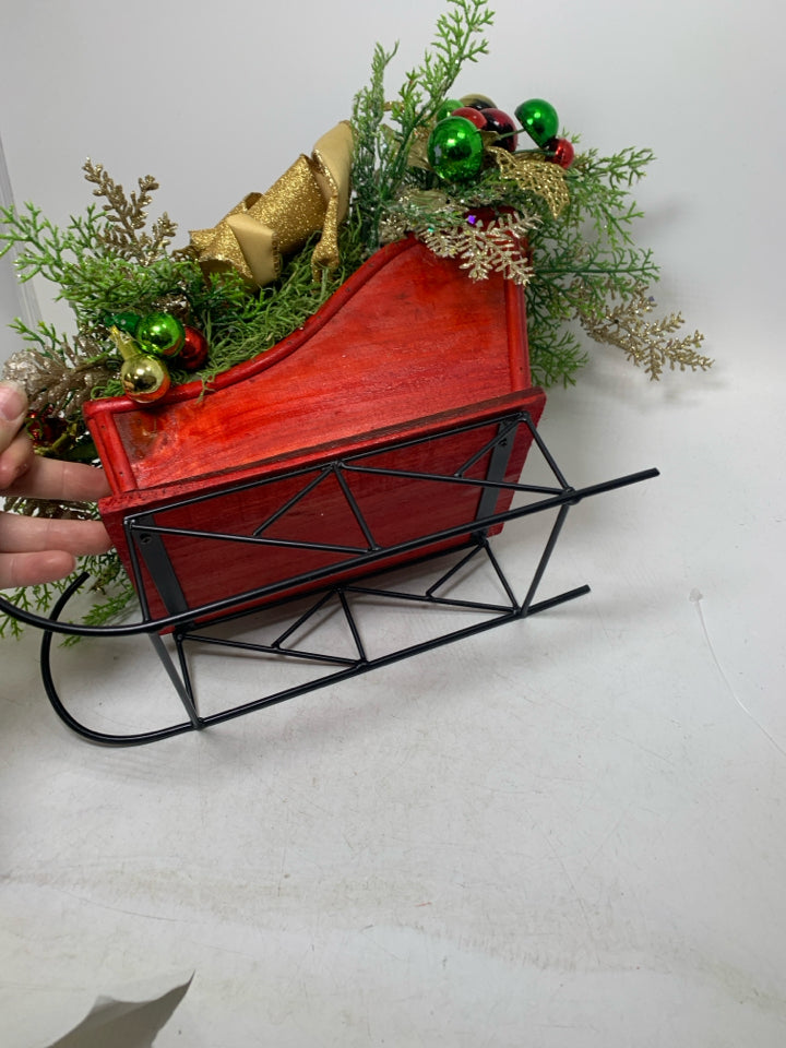 RED SLEIGH W/ HOLIDAY FLORAL ARRANGEMENT.