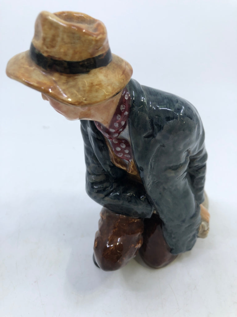 VTG "THE POACHER" KNEELING MAN WITH BLUE COAT AND TAN HAT.