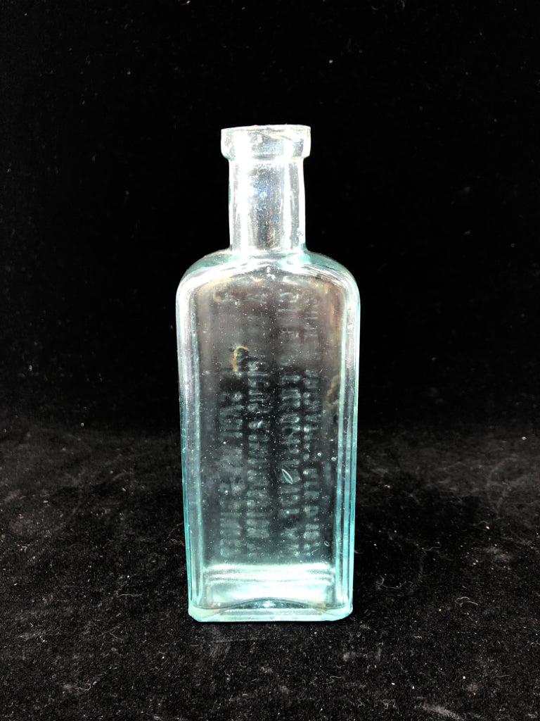 EMPTY LIGHT BLUE GLASS BOTTLE W/ WRITING.