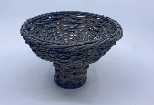 GRAY WOVEN METAL FOOTED BASKET.