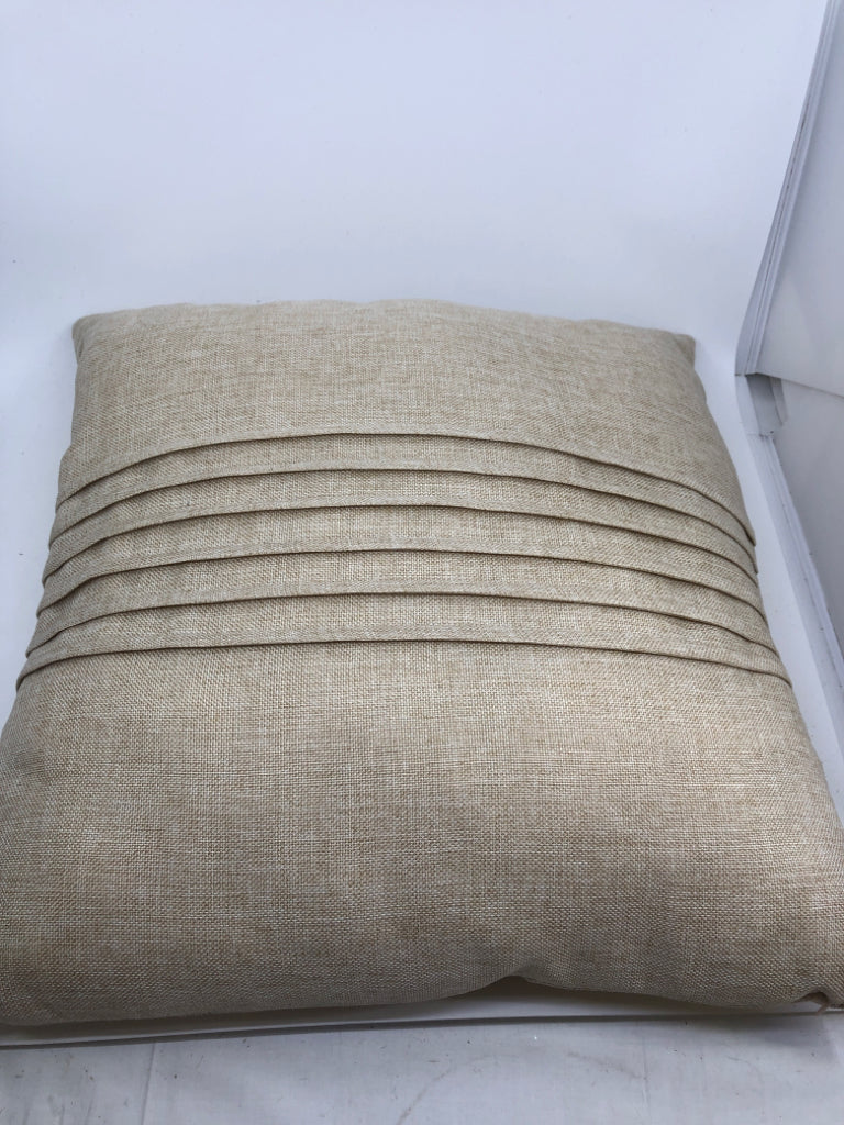 BEIGE PILLOW W/ PLEATS IN MIDDLE.
