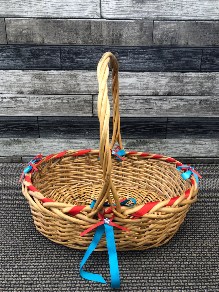 BLONDE WICKER BASKET W/BLUE AND RED BOWS.