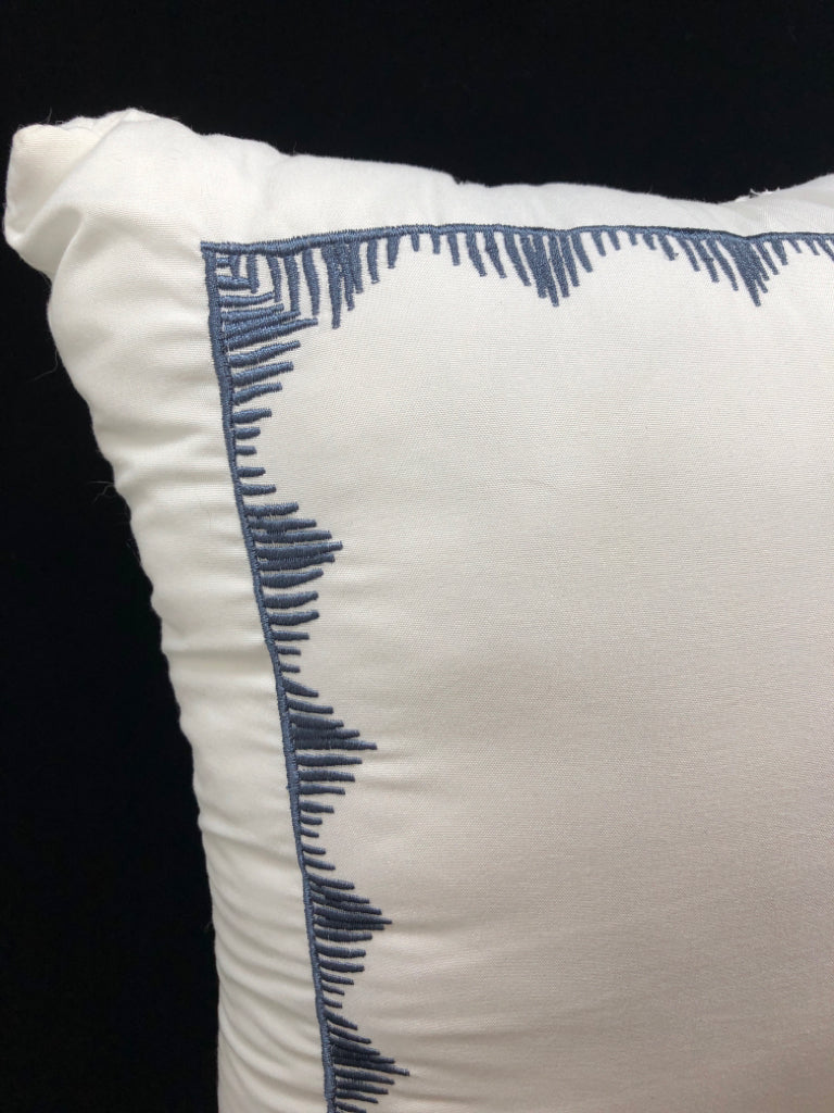 WHITE THROW PILLOW W/GEOMETRIC BLUE PATTERN.