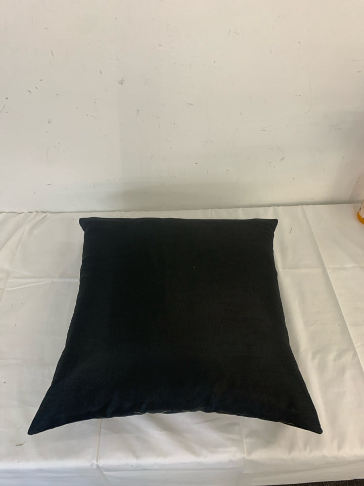 BLACK PILLOW WITH BROWN AND TAN CIRCLE.