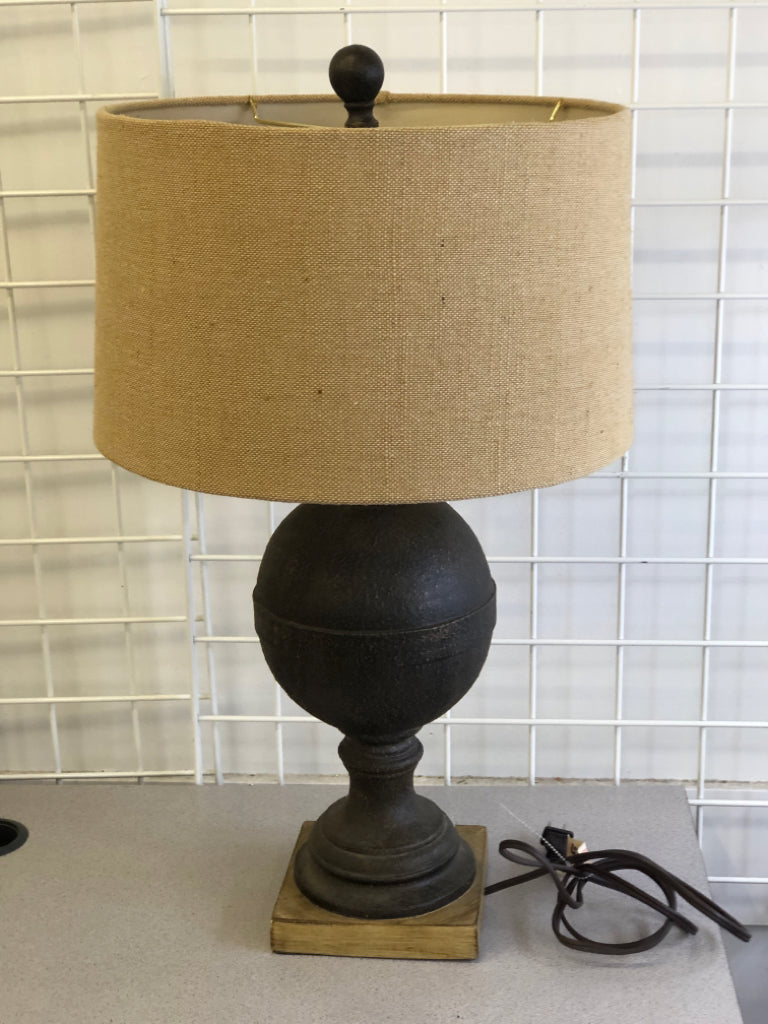 DARK BROWN TEXTURED BASE ON WOOD SLAB W/ BURLAP SHADE.