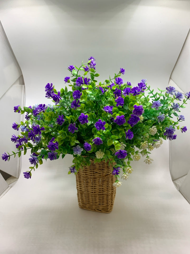 FAUX PURPLE AND GREENERY IN WICKER BASKET.