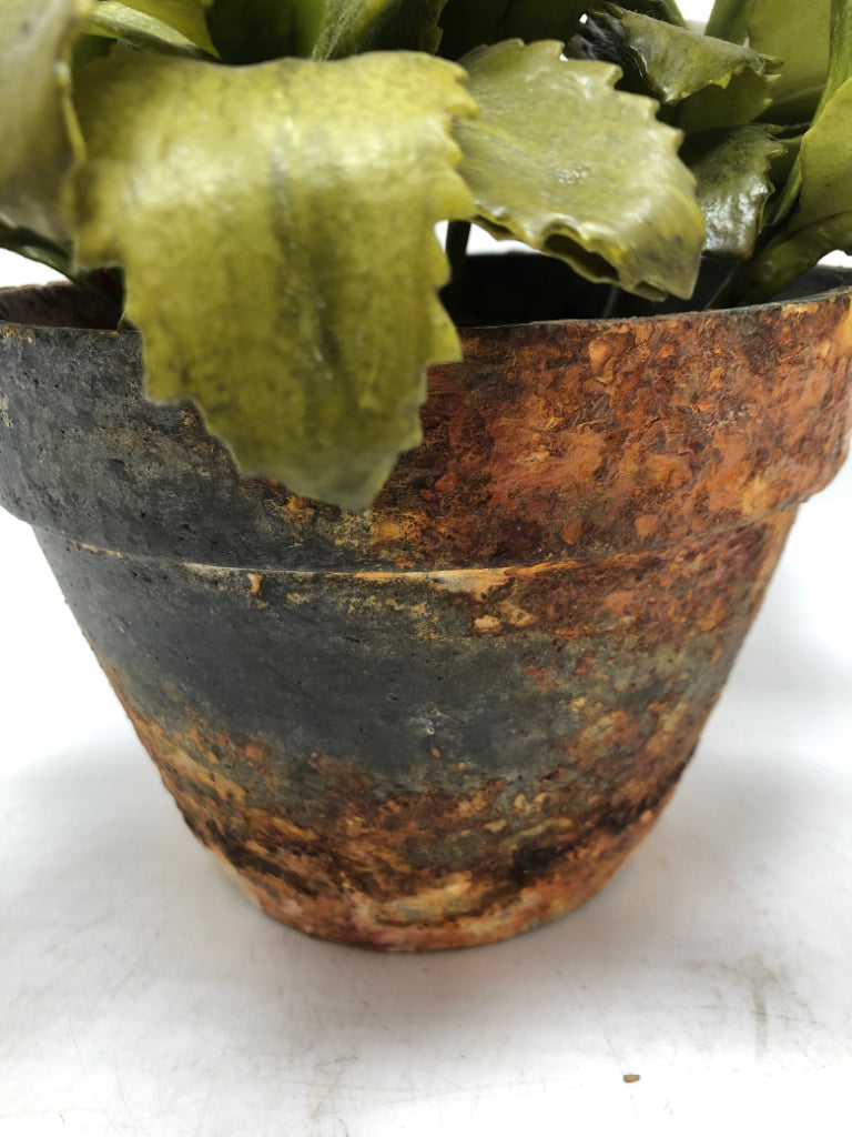 FAUX PINK FLOWERS IN RUSTIC CEMENT POT.