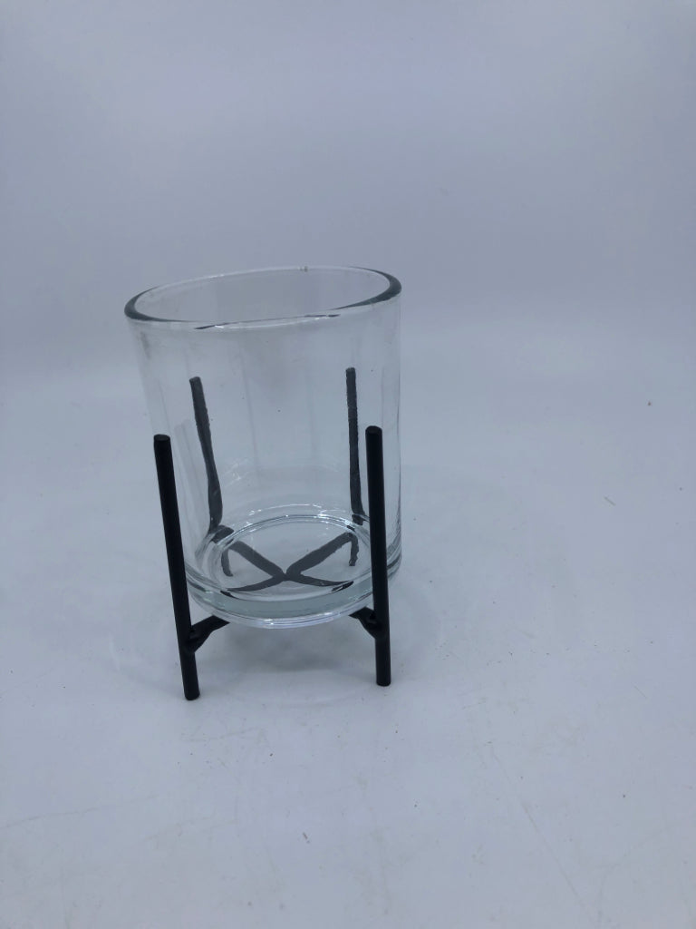 SMALL GLASS VOTIVE HOLDER IN BLACK METAL STAND.