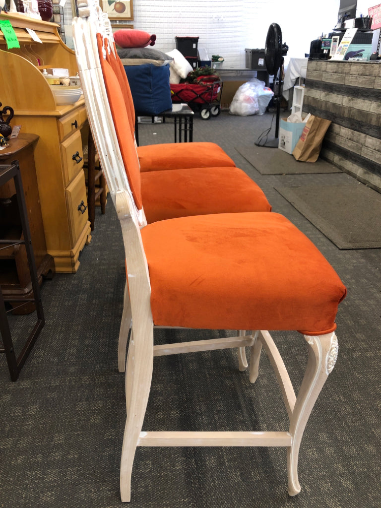 3 BURNT ORANGE UPHOLSTERED WHITE WASHED BAR STOOLS W/ FLORAL DESIGN ON BACK.