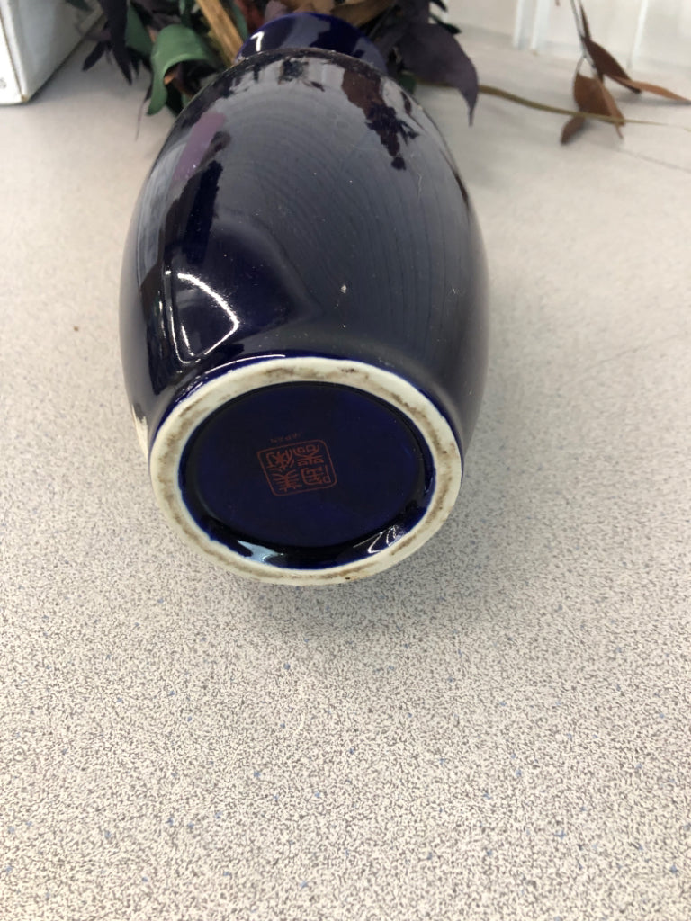FAUX DARK FOLIAGE IN BLUE FLORAL VASE.