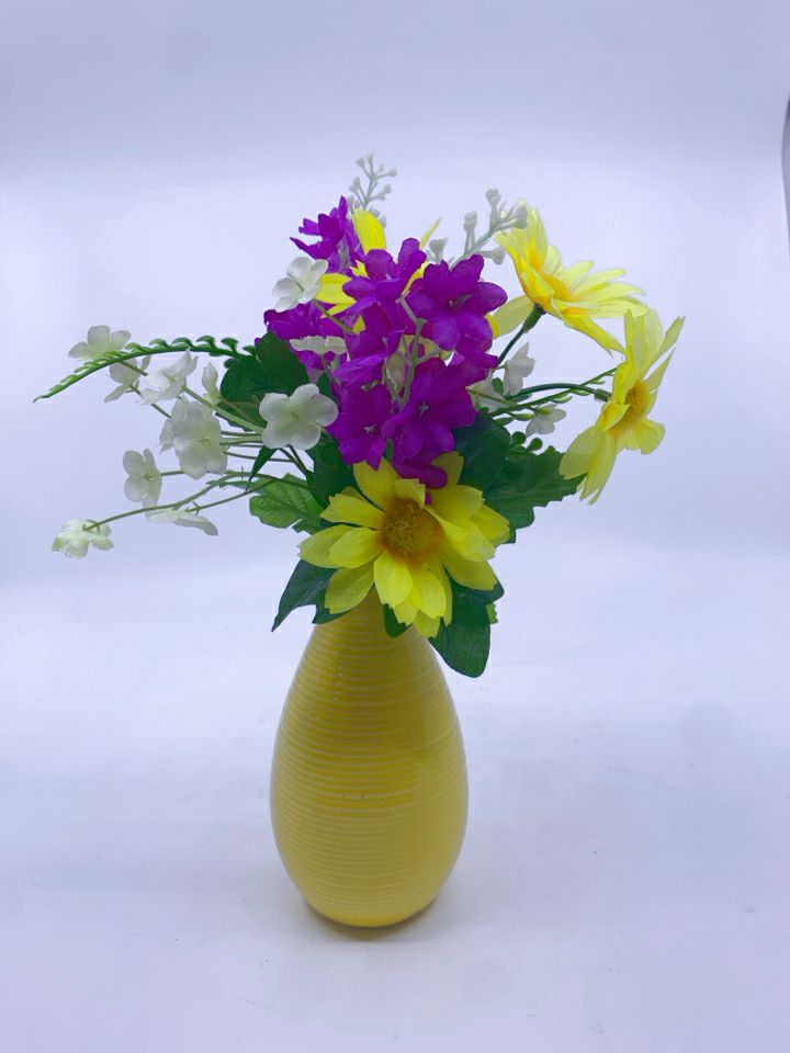 YELLOW AND PURPLE FAUX FLORAL IN YELLOW VASE.